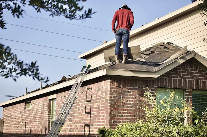 Professional roofer working on a residential roof in Kechi